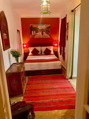 a bedroom with a bed and a red wall at Dar Zemrane in Marrakech