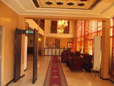 a hallway with a lobby with chairs and a table at Hotel Al Kabir in Marrakech