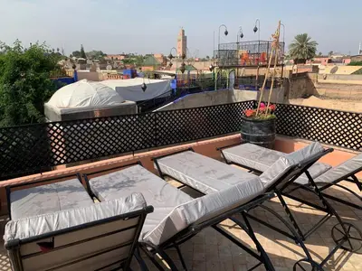 a couple of chairs and tables on a roof at Riad Abaka hotel & boutique in Marrakech