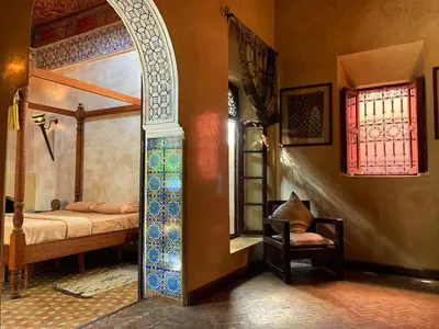 a room with a bedroom with a bed and a window at Riad Bamileke in Marrakech