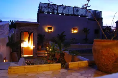 a house with a patio with a porch and a building at Riad Bamileke in Marrakech