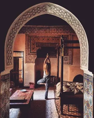 a person sitting on a bed in a room at Riad Bamileke in Marrakech