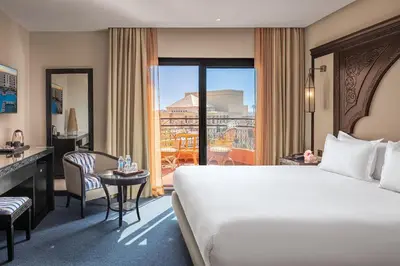 a hotel room with a bed and a desk and a window at Grand Plaza Marrakech in Marrakech