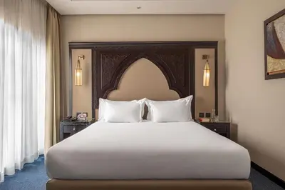 a bedroom with a large bed with white pillows at Grand Plaza Marrakech in Marrakech