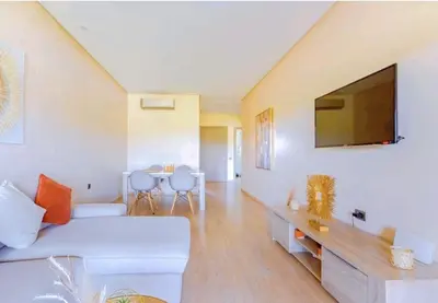 a living room with a white couch and a flat screen tv at Marrakech golf city prestigia in Marrakech