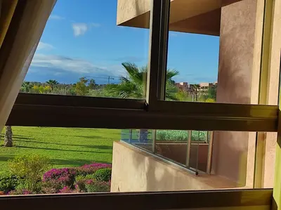 an open window with a view of a garden at Marrakech golf city prestigia in Marrakech