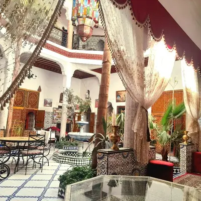 a lobby with tables and chairs in a building at Riad Chennaoui in Marrakech
