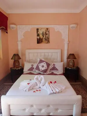 a bedroom with a white bed with towels on it at Riad Chennaoui in Marrakech