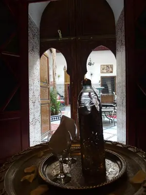 a bottle sitting on top of a table with a wine glass at Riad Chennaoui in Marrakech