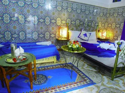 a room with two beds and a table in it at Riad Chennaoui in Marrakech