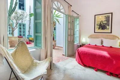 a bedroom with a red bed and a window at Riad Helen in Marrakech