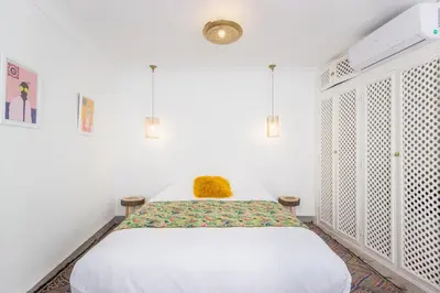 a bedroom with a bed with a yellow pillow on it at Riad Helen in Marrakech