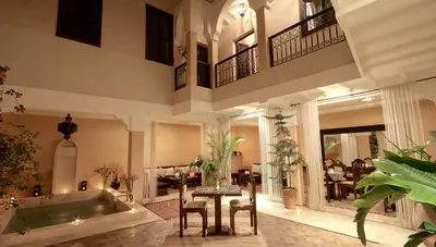a large living room with a bath tub and a table at Riad Karmanda in Marrakech