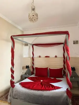 a bedroom with a red and white canopy bed at Riad Karmanda in Marrakech