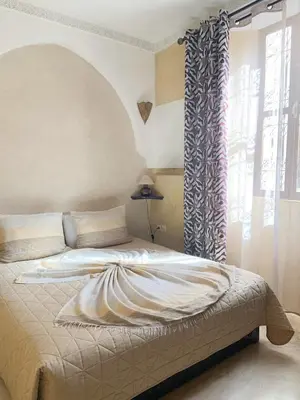 a bedroom with a large bed with a window at Riad Karmanda in Marrakech