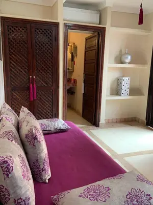 a bed with purple sheets and pillows in a room at Riad Karmanda in Marrakech