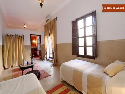 a bedroom with two beds and a window at Riad Sidi Ayoub in Marrakech