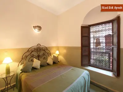 a bedroom with a bed and a window at Riad Sidi Ayoub in Marrakech