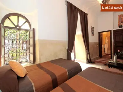 a bedroom with two beds and a window at Riad Sidi Ayoub in Marrakech
