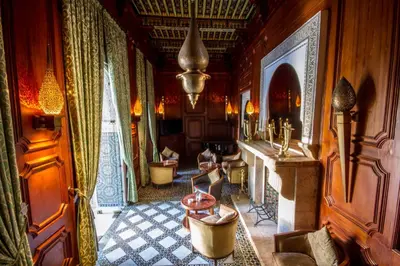 a living room with a table and chairs in a room at Palais Dar Donab in Marrakech