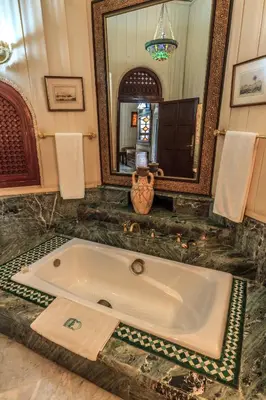 a large bath tub in a bathroom with a mirror at Palais Dar Donab in Marrakech