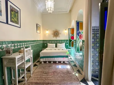 a bedroom with a bed in a room with tiles at Riad Ksar Fawz & Spa in Marrakech