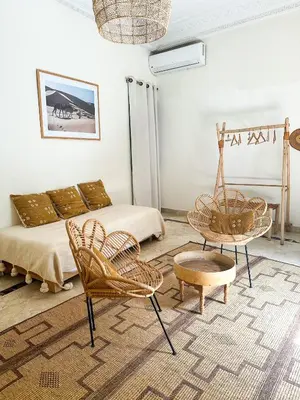 a living room with rattan chairs and a bed at Riad Ksar Fawz & Spa in Marrakech