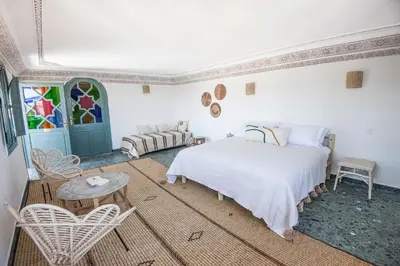 a bedroom with a bed and a table and chairs at Riad Ksar Fawz & Spa in Marrakech