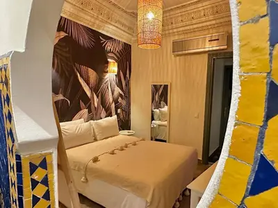a bedroom with a bed and a painting on the wall at Riad Ksar Fawz & Spa in Marrakech