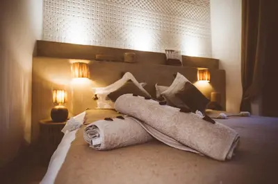 a bedroom with a bed with towels and two lights at Riad Bamboo Suites & Spa in Marrakech