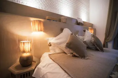 a bedroom with a bed with pillows and two lamps at Riad Bamboo Suites & Spa in Marrakech