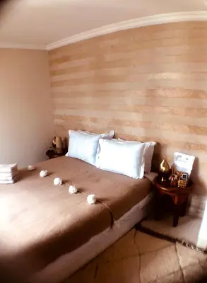 a bedroom with a large bed with a wooden headboard at Riad Bamboo Suites & Spa in Marrakech