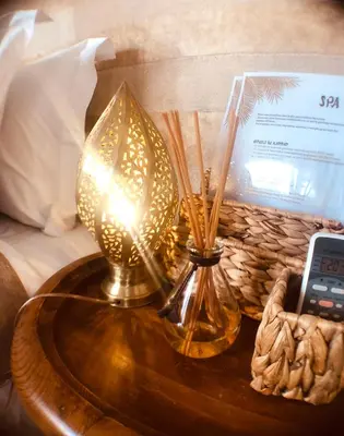 a lamp on a table next to a bed at Riad Bamboo Suites & Spa in Marrakech