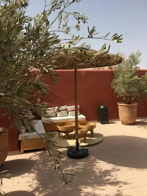 a patio with a table and a umbrella at Riad Alia in Marrakech