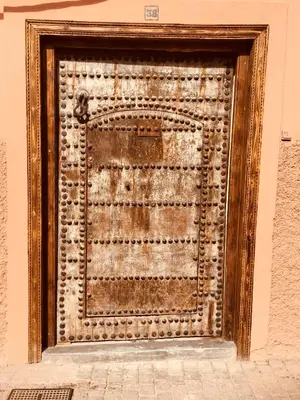 an old metal door on a wall at Riad Alia in Marrakech