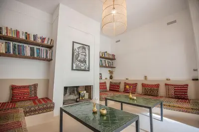 a living room with couches and tables and a fireplace at Riad Alia in Marrakech