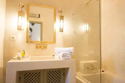 a bathroom with a sink and a shower with a mirror at Riad Alia in Marrakech