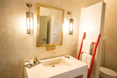 a bathroom with a sink and a mirror and a toilet at Riad Alia in Marrakech