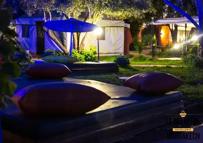 a group of pillows on a table with an umbrella at Le Relais De Marrakech in Marrakech