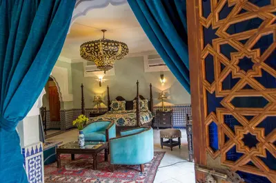 a bedroom with a bed and a chandelier at Riad Palais Sebban in Marrakech