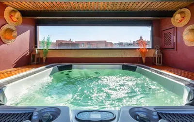 a hot tub in a room with a large window at Riad l'Heure d'Eté in Marrakech