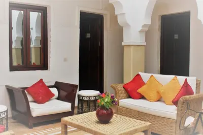 a living room with two chairs and a couch with colorful pillows at Les Jardins Mandaline in Marrakech