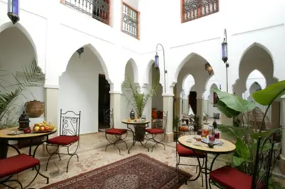 a courtyard with tables and chairs in a building at Les Jardins Mandaline in Marrakech