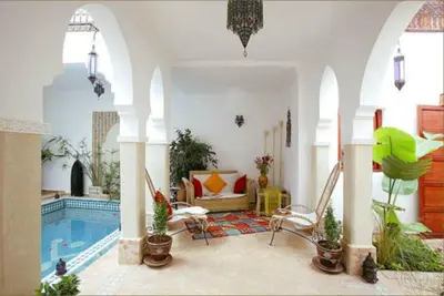 a living room with a swimming pool in a house at Les Jardins Mandaline in Marrakech
