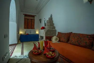 a living room with a couch and a table with food at Riad Safran et Cannelle & Spa in Marrakech