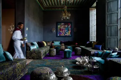 a man walking into a living room with couches at Tigmiza Boutique Hotel & Spa in Marrakech