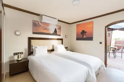 a bedroom with two beds with white sheets at Riad Ushuaia - Centre Marrakech in Marrakech