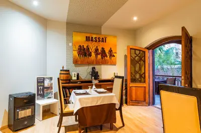 a dining room with a table and a television at Riad Ushuaia - Centre Marrakech in Marrakech