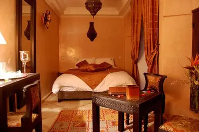a bedroom with a bed and a table with a table sidx sidx sidx at Riad D'Airain in Marrakech