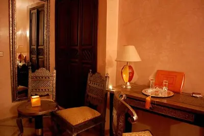 a room with a desk with a lamp and a table at Riad D'Airain in Marrakech